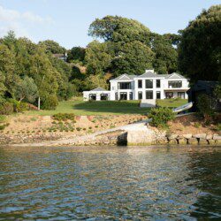 a large white house sitting on top of a lush green hillside
