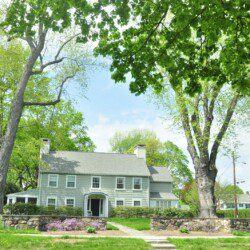 white and gray house near green trees during daytime